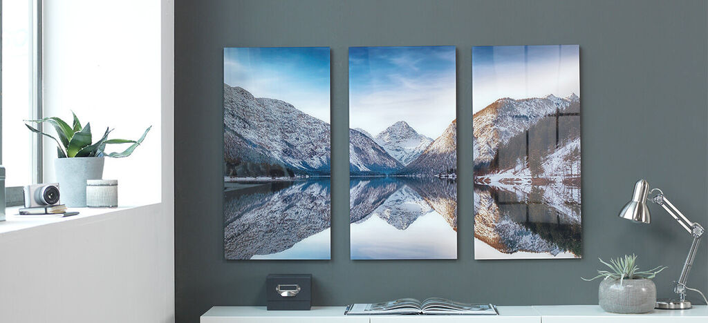Trois belles images de montagnes enneigées et d'un lac clair accrochées à un mur.