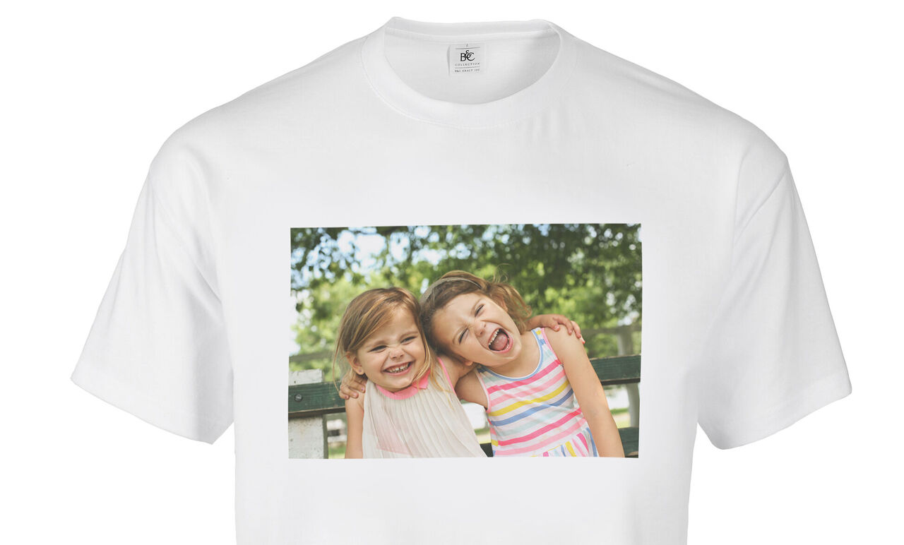 Deux enfants en T-shirts colorés s'enlacent avec bonheur à l'extérieur.
