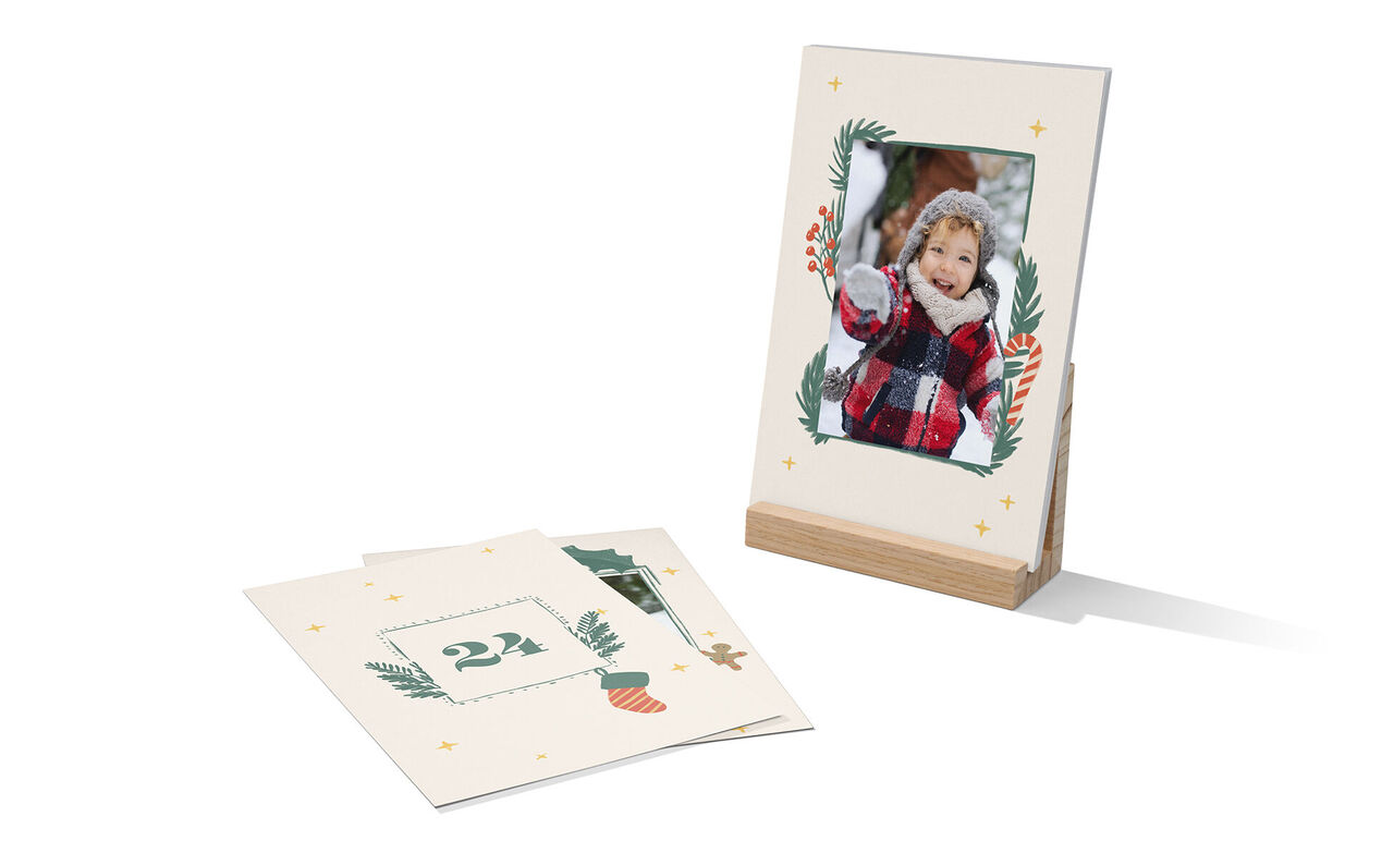 Un cadre photo soigné fait de papier recyclé montre un motif festif. Une feuille de décoration avec le nombre 24 à côté.
