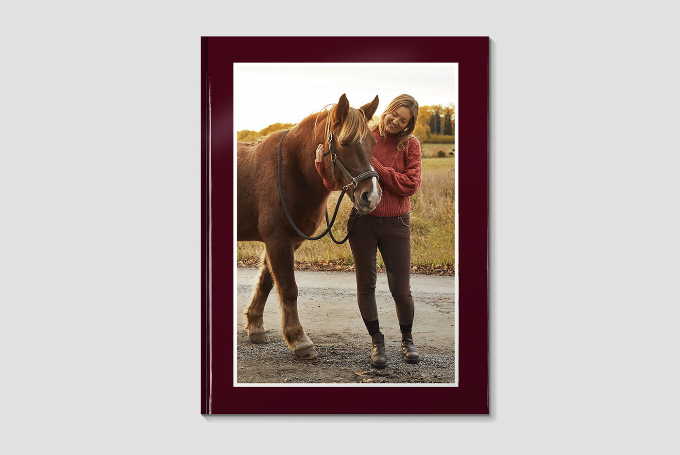 Une femme heureuse enlace un cheval dans un champ. La scène exprime joie et connexion.