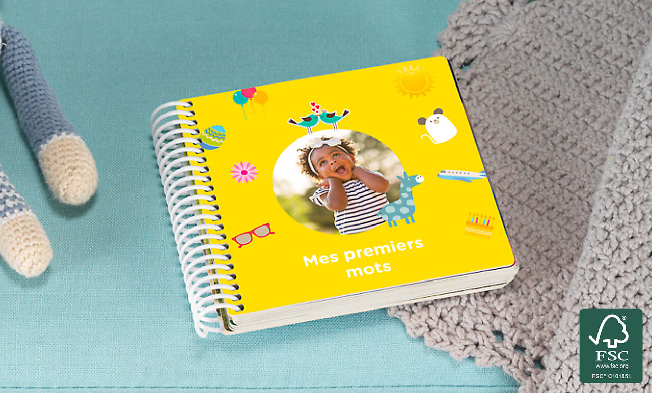 Un livre photo coloré et joyeux intitulé "Mes premiers mots" sur fond bleu clair.