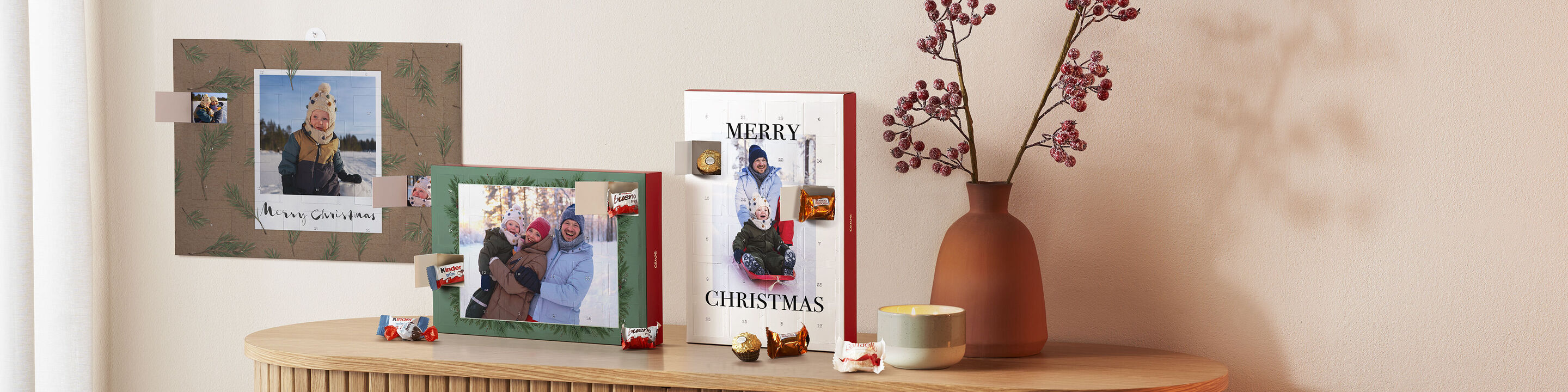 Une décoration de Noël festive avec un livre photo CEWE et des cartes photo personnelles sur une table.