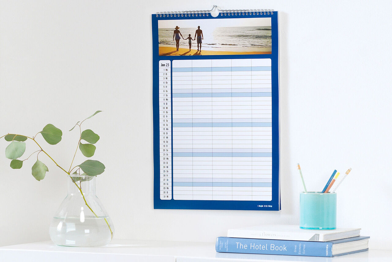 Un calendrier photo personnel avec une image de deux personnes à la plage et un outil de planification clair.