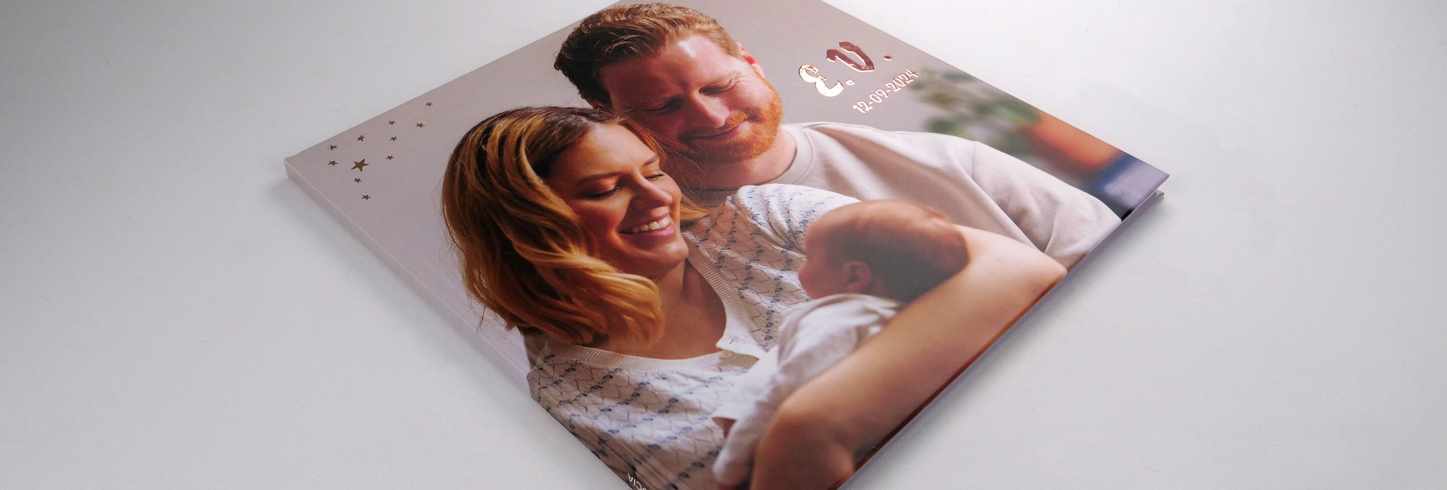 Le CEWE FOTOBUCH montre une famille heureuse avec un bébé.