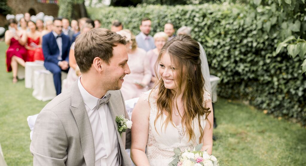 Un couple heureux lors de son mariage en plein air, entouré d'invités