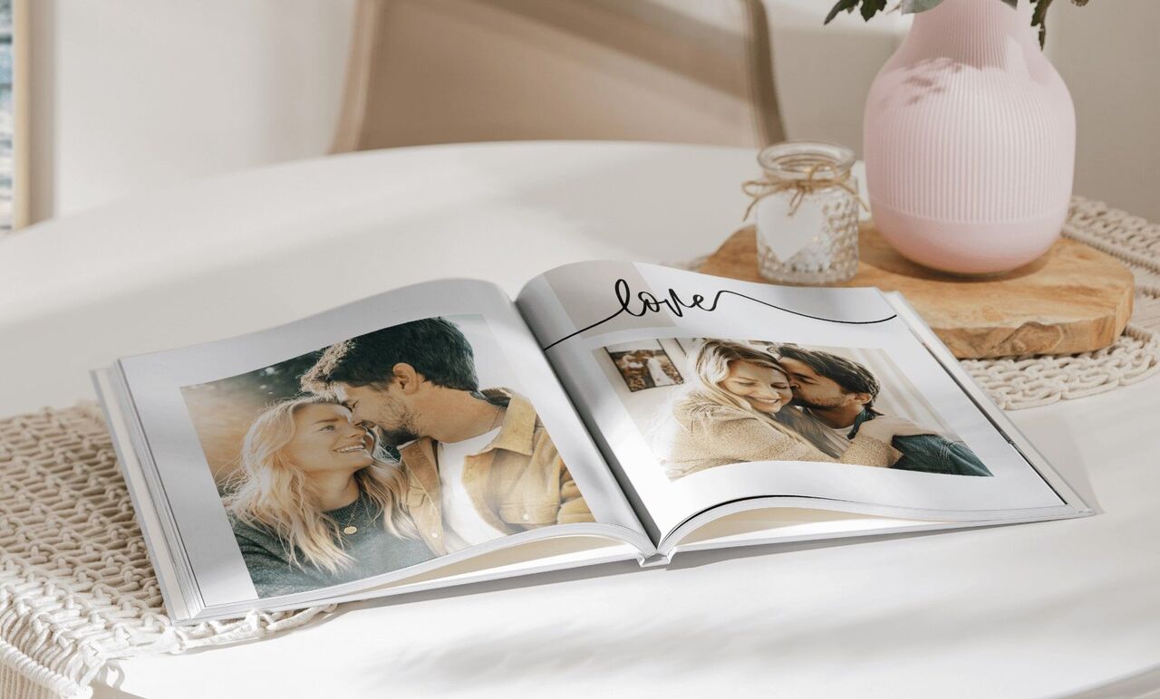 Livre photo ouvert sur une table avec deux photos d'un couple et le mot 'love'.
