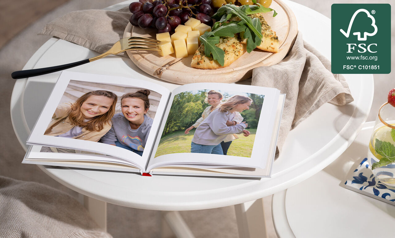 Un livre photo ouvert sur une table avec des aliments frais. Les pages montrent deux enfants jouant dehors.