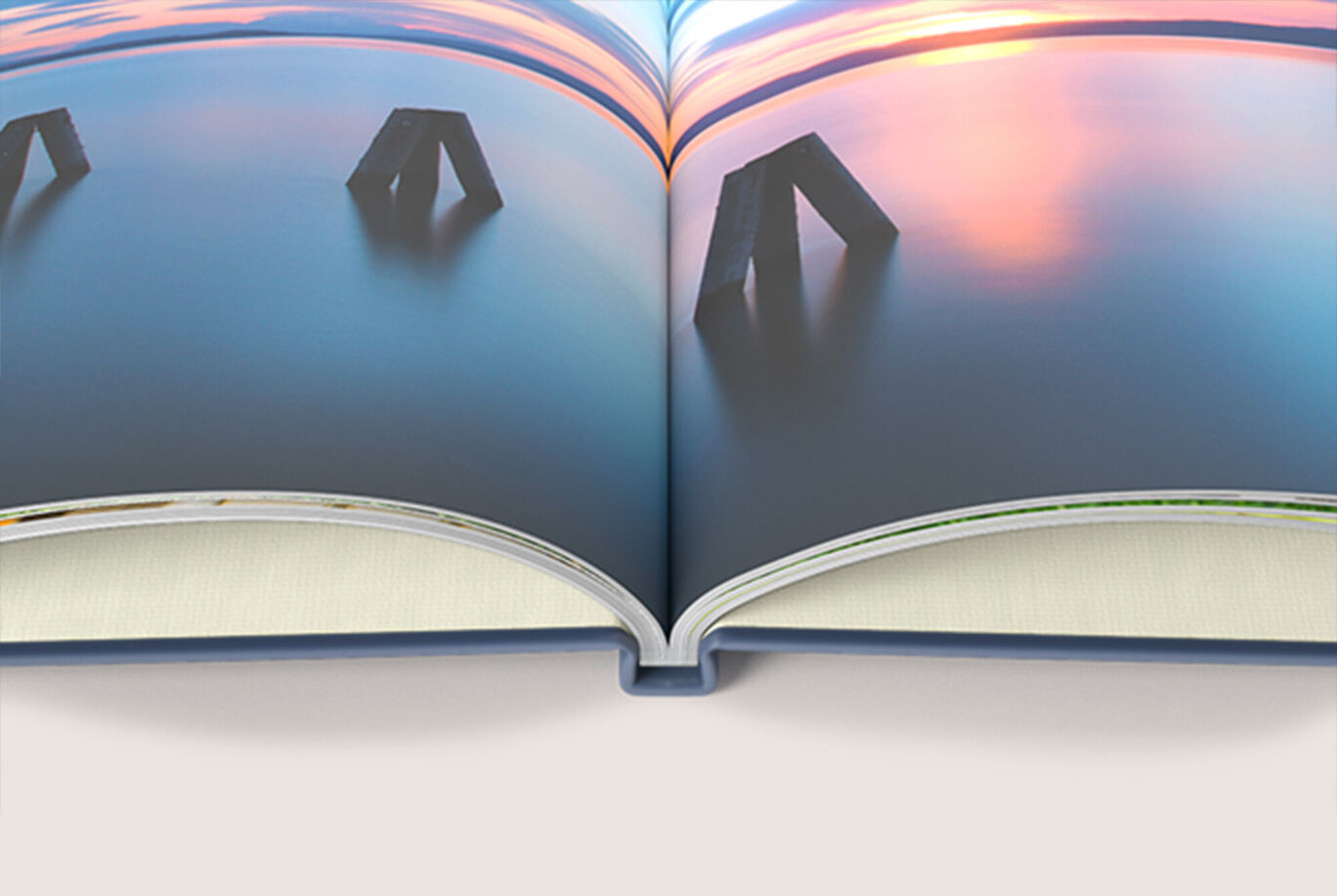 CEWE PHOTOBOOK ouvert avec des images de paysage calme et de statues, couleurs douces reflétant dans l'eau