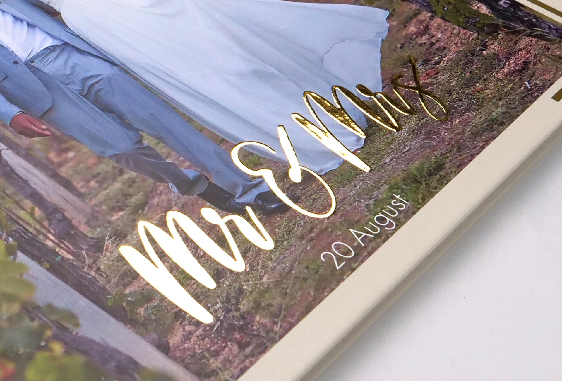 Vue en détail d'un album de mariage avec l'inscription dorée 'Mr & Mrs' et la date '20 août'.