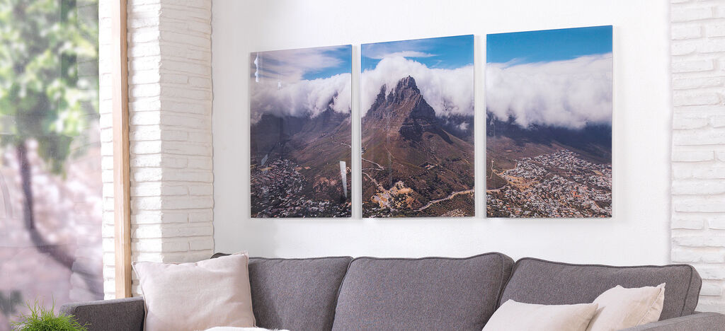 Trois images encadrées d'une montagne avec des nuages sur la ville.
