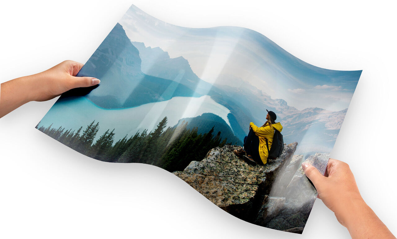 Person en veste jaune assise sur un rocher, regardant un lac et des montagnes