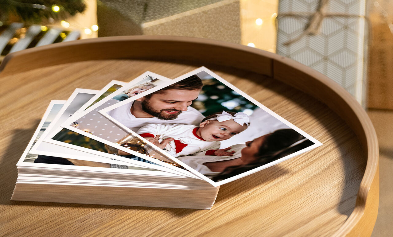 Plusieurs photos sont sur un plateau en bois, dont une famille joyeuse partage un moment spécial