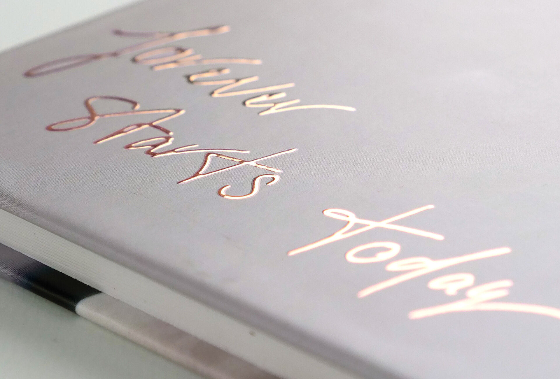 Un livre photo avec un titre créatif, manuscrit sur la couverture. Le titre est conçu en lettres cursives élégantes en or rose.