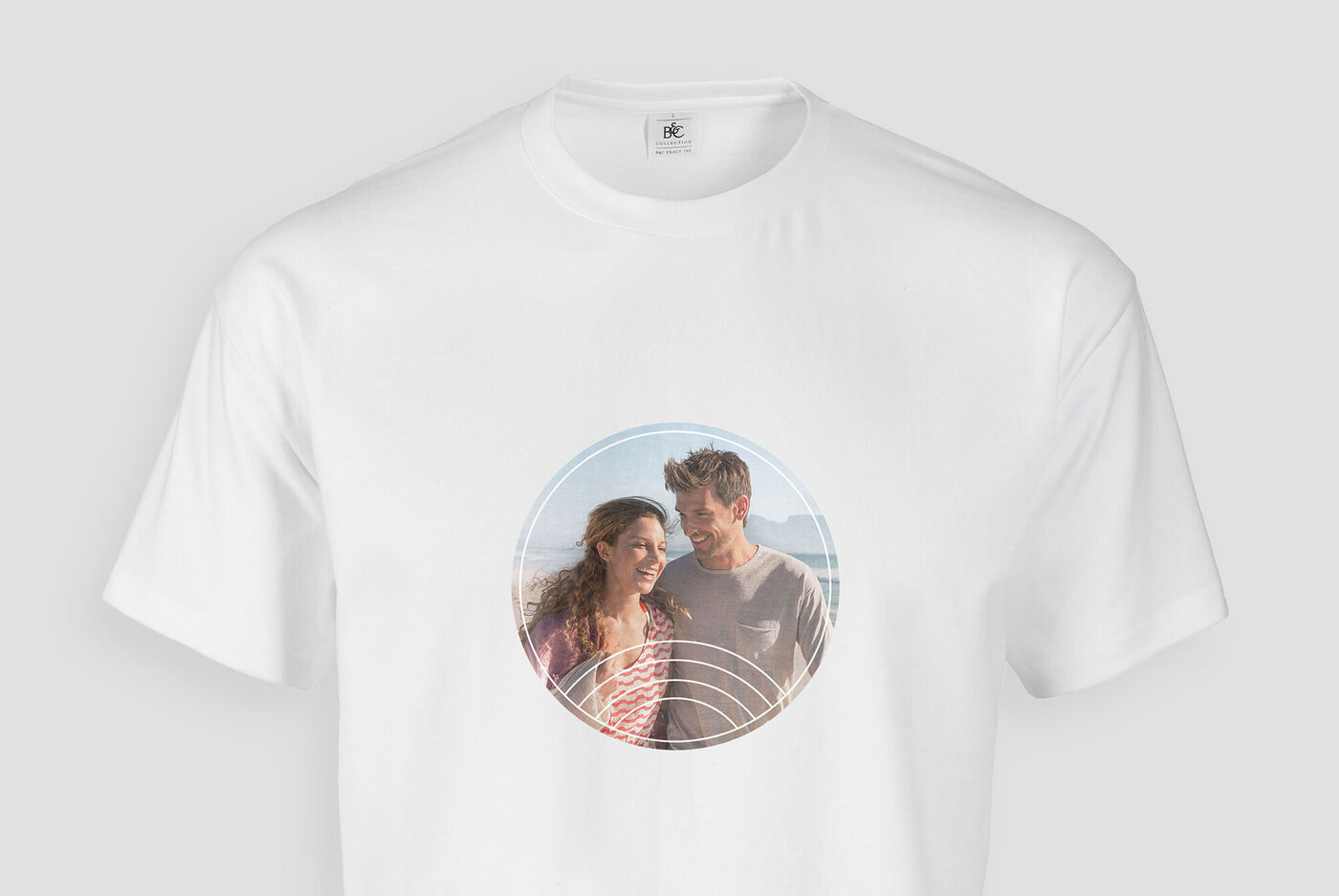 Un couple en t-shirt blanc avec une image ronde dans un cadre, rayonnant de joie.