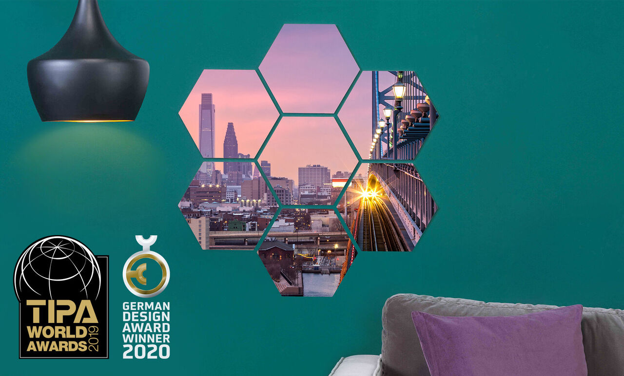 Décoration murale colorée avec des photos hexagonales d'une vue de ville au coucher de soleil et d'un pont.