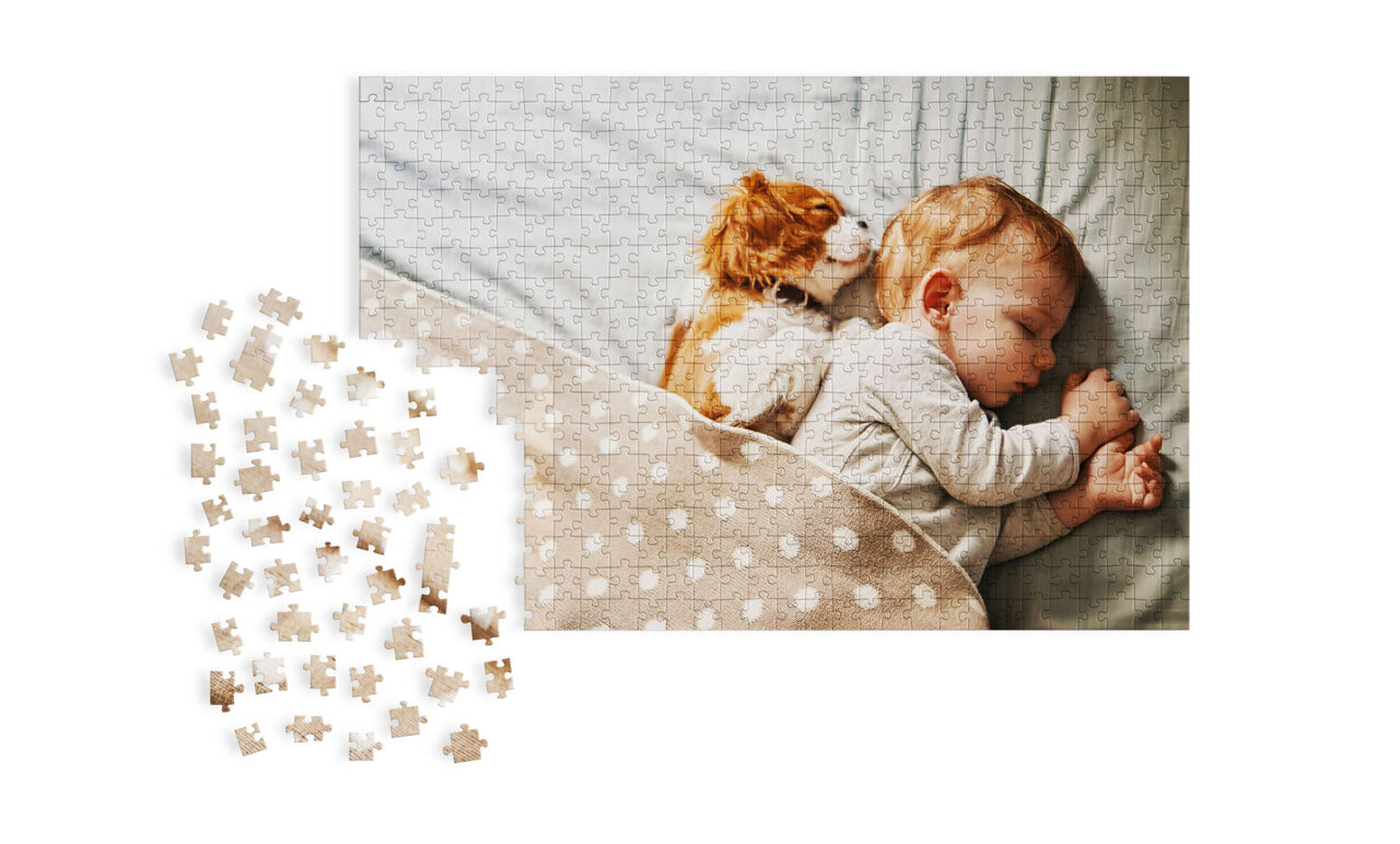 Un bébé endormi est allongé sur un lit, entouré d'une housse de couette douce à pois. Un petit chien se blottit contre le bébé.