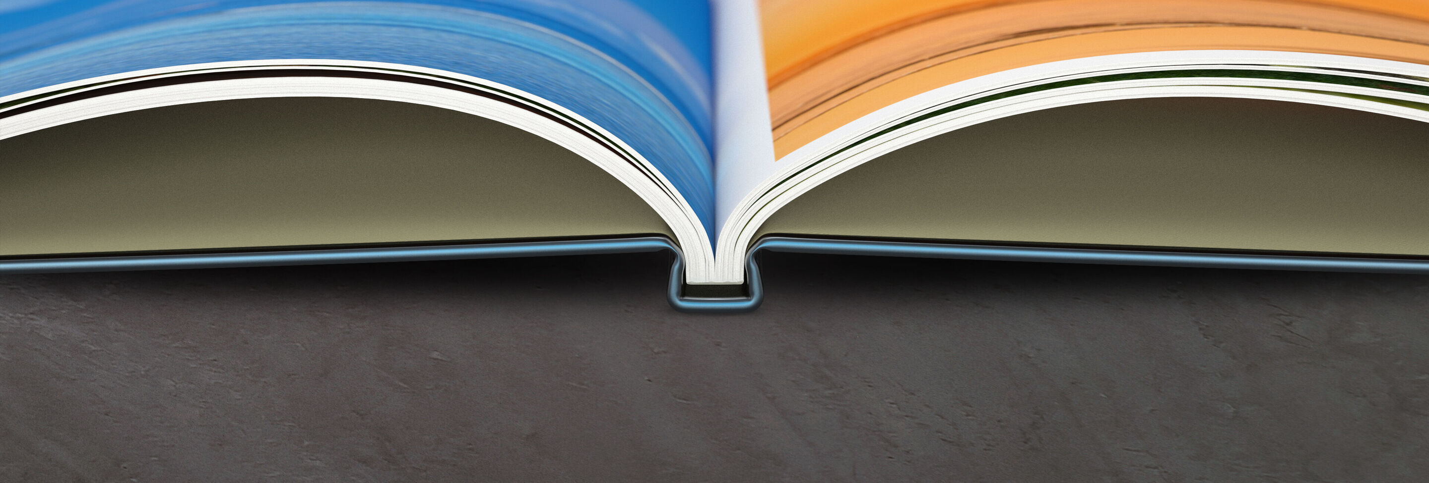 Un livre photo ouvert avec des pages colorées en orange et bleu.