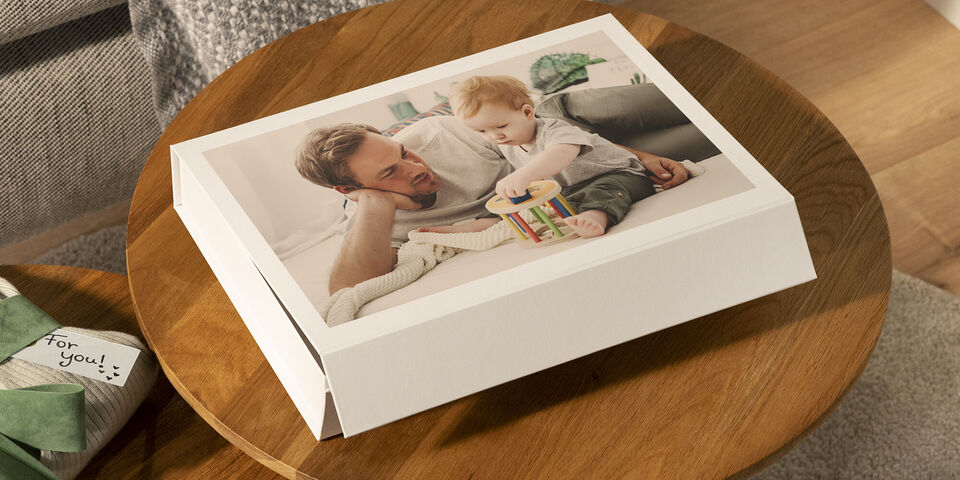 Un père joue avec son enfant sur une table.