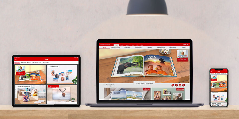 Un ordinateur, une tablette et un smartphone montrent le site CEWE FOTOBUCH avec des exemples colorés de livres photo. De beaux souvenirs.