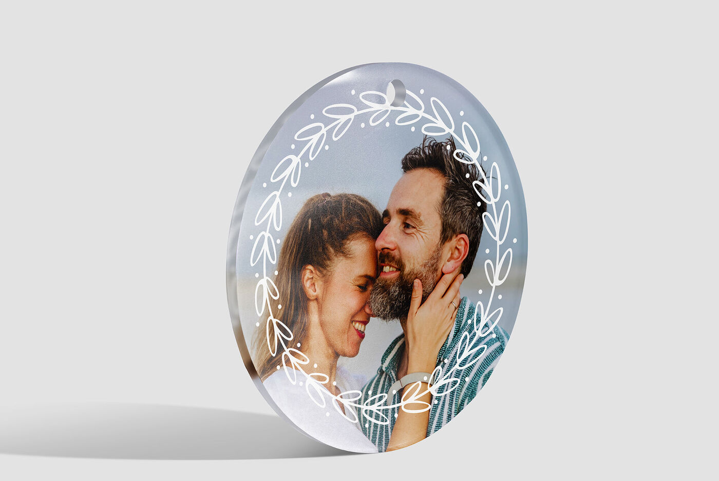 Un produit photo rond et transparent avec un couple aimant et des détails floraux en arrière-plan.
