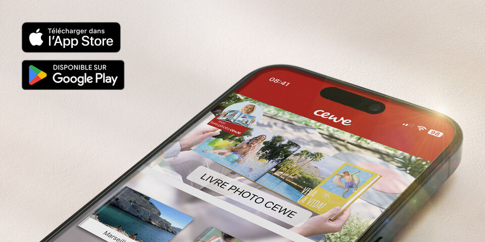 Un smartphone montre l'application CEWE avec un album photo et des photos