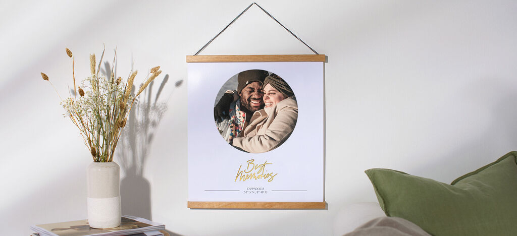 Un couple souriant s'enlace dans un cadre, entouré de fleurs et d'un coussin décoratif.