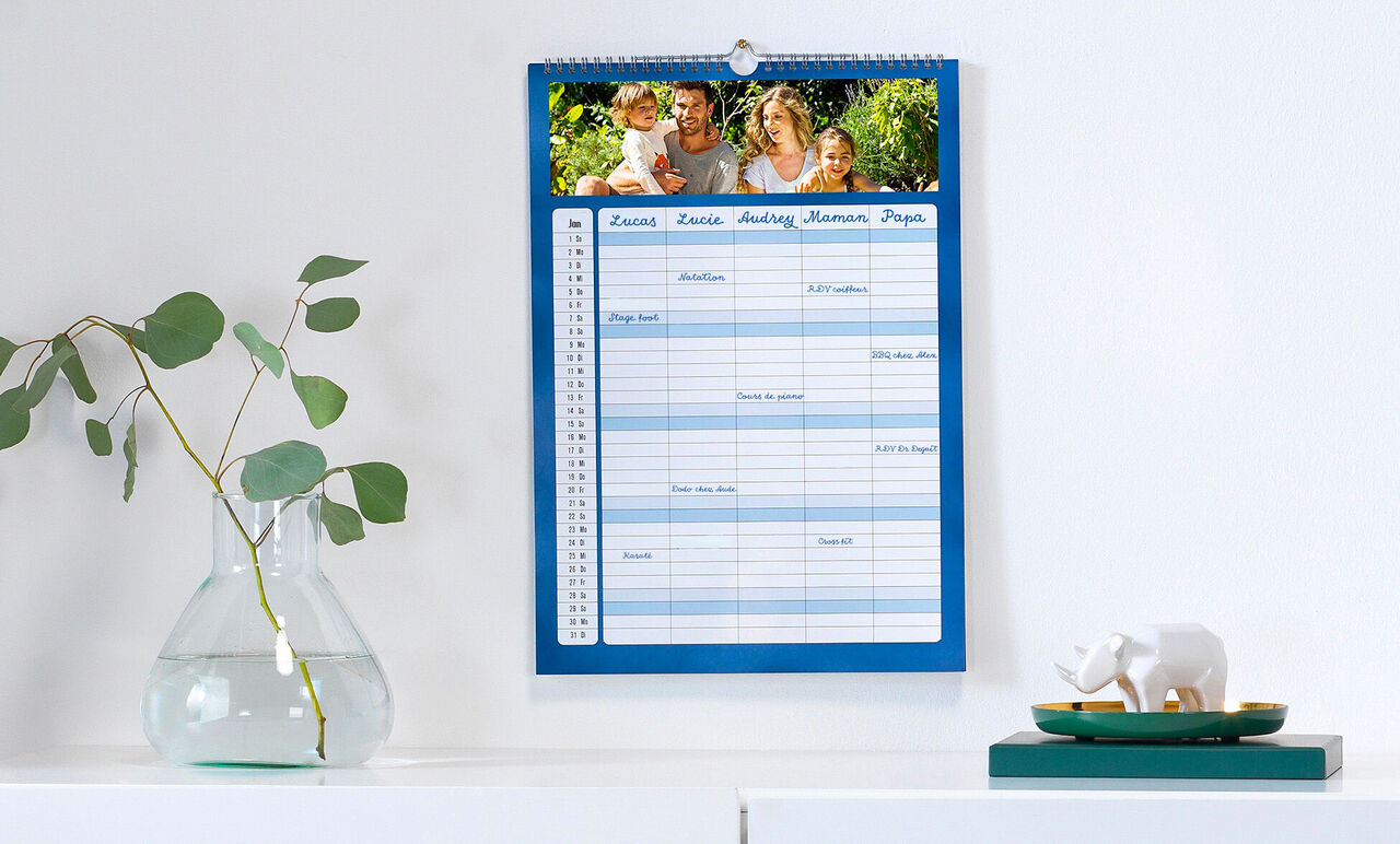 Un calendrier mural avec des photos d'une famille heureuse passant du temps ensemble.