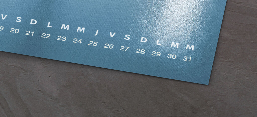 Gros plan d'un calendrier mural bleu avec des chiffres et jours artistiques