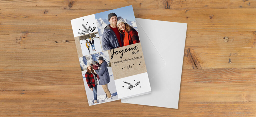 Femme et homme en vêtements chauds avec une carte de vœux de vacances devant une surface en bois.