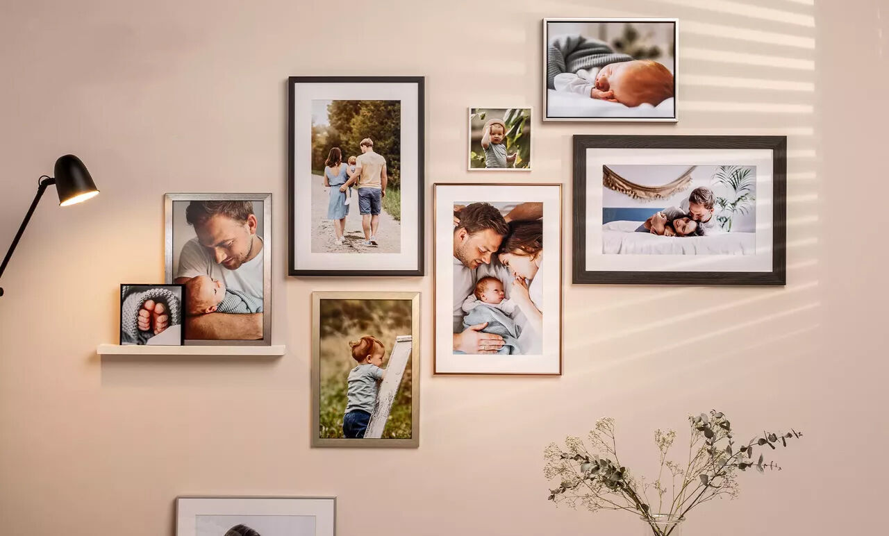 Décoration murale avec des photos de famille encadrées en couleurs claires