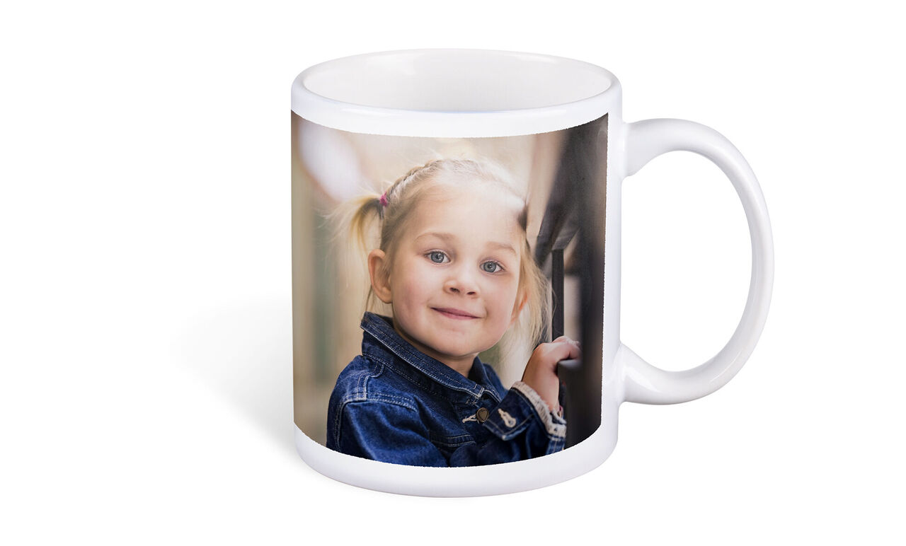Une tasse avec une photo d'un enfant regardant joyeusement par la fenêtre