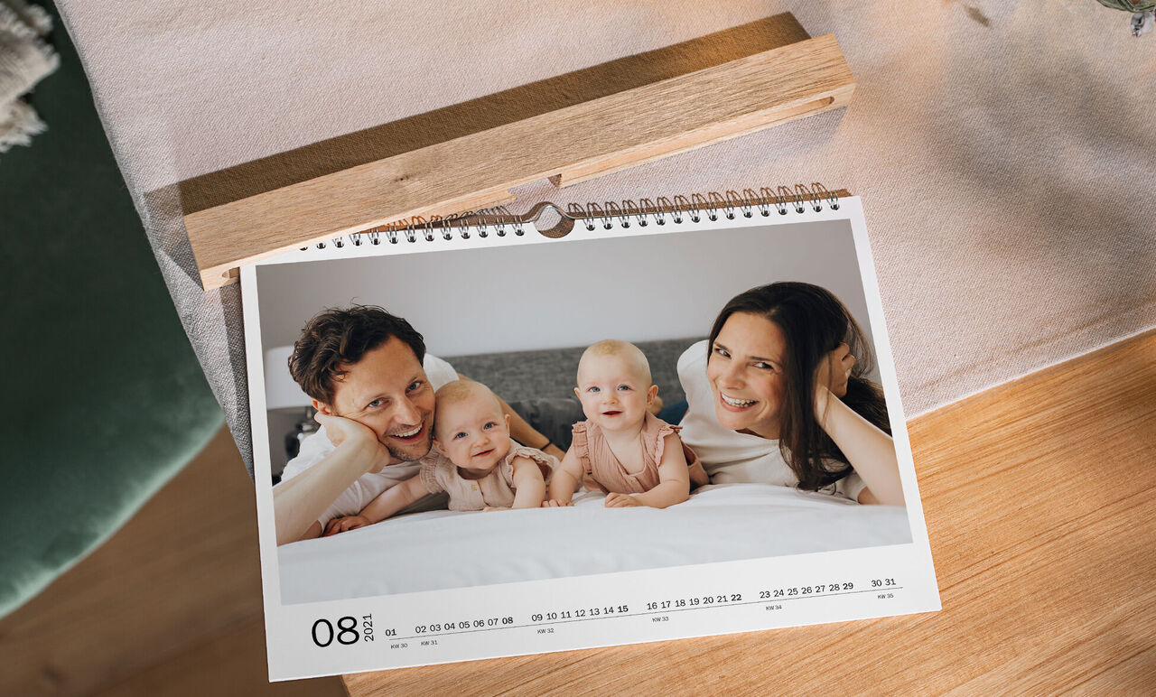 Une famille admire un calendrier photo conçu avec amour, affichant une vue mensuelle spéciale.