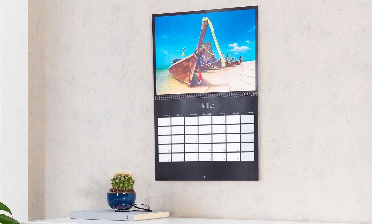 Un calendrier montre une scène colorée de plage avec des chaises colorées et un beau ciel bleu.