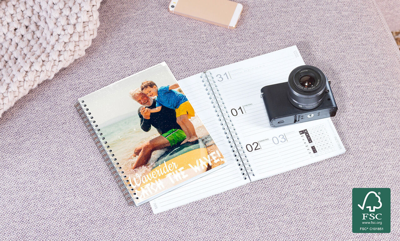 Un carnet ouvert avec une photo de la caméra et une photo de deux personnes sur la plage