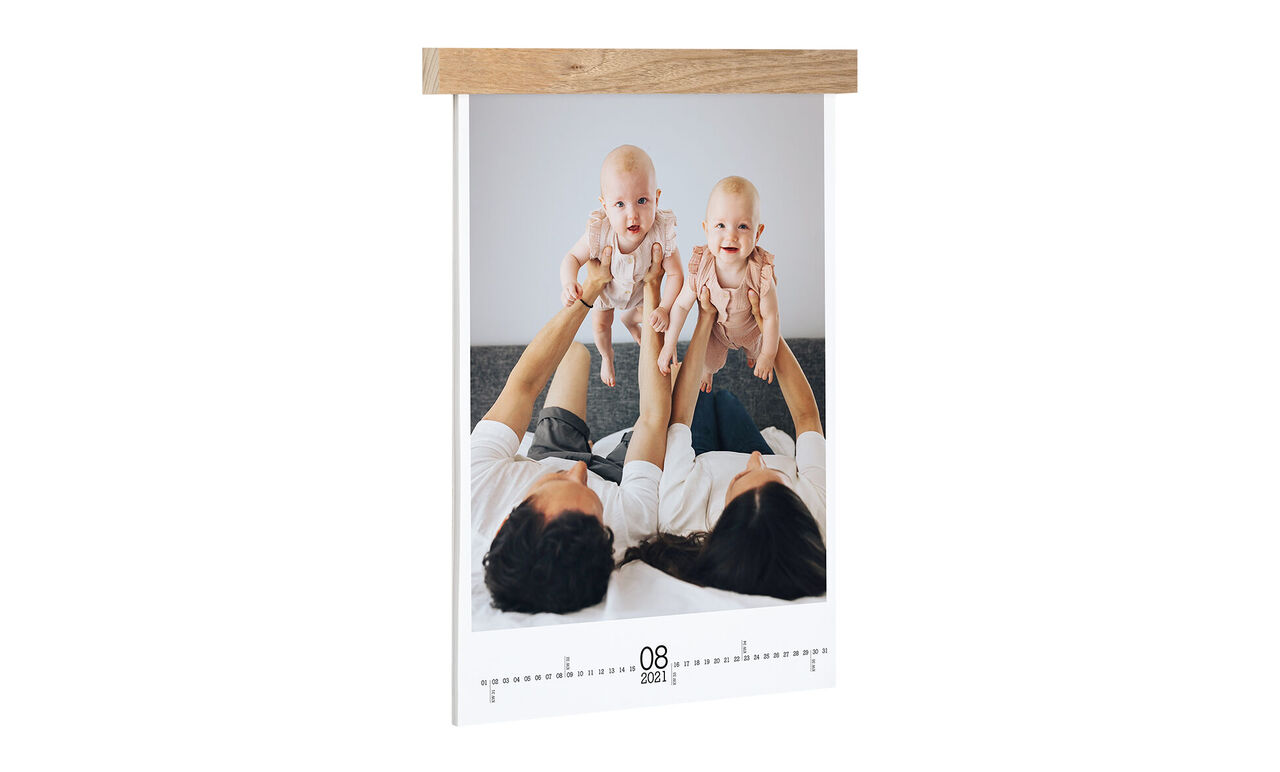 Des parents tiennent leurs bébés en l'air, un moment merveilleux capturé dans un calendrier CEWE.
