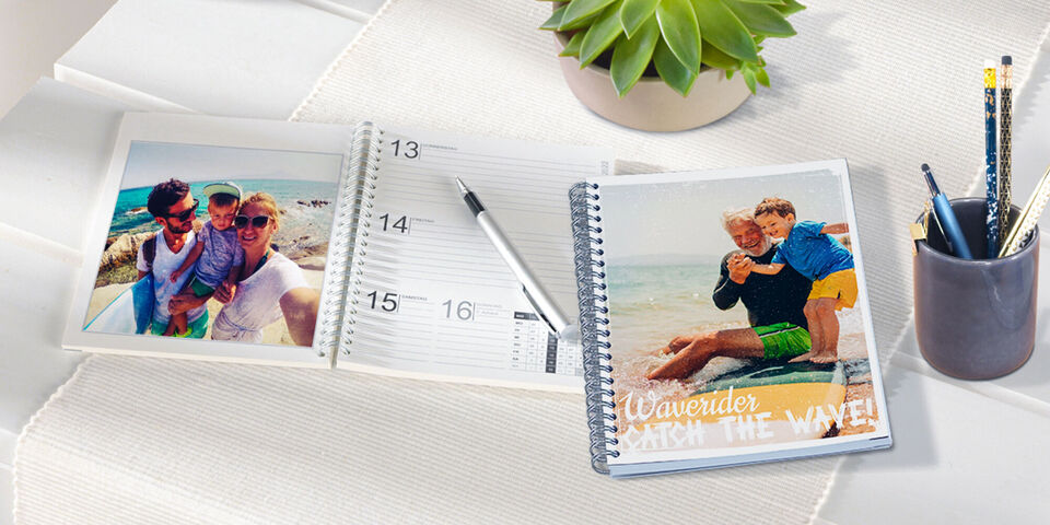 Livre photo ouvert avec deux photos et un calendrier. Le texte 'Show the Way' est sur la droite.