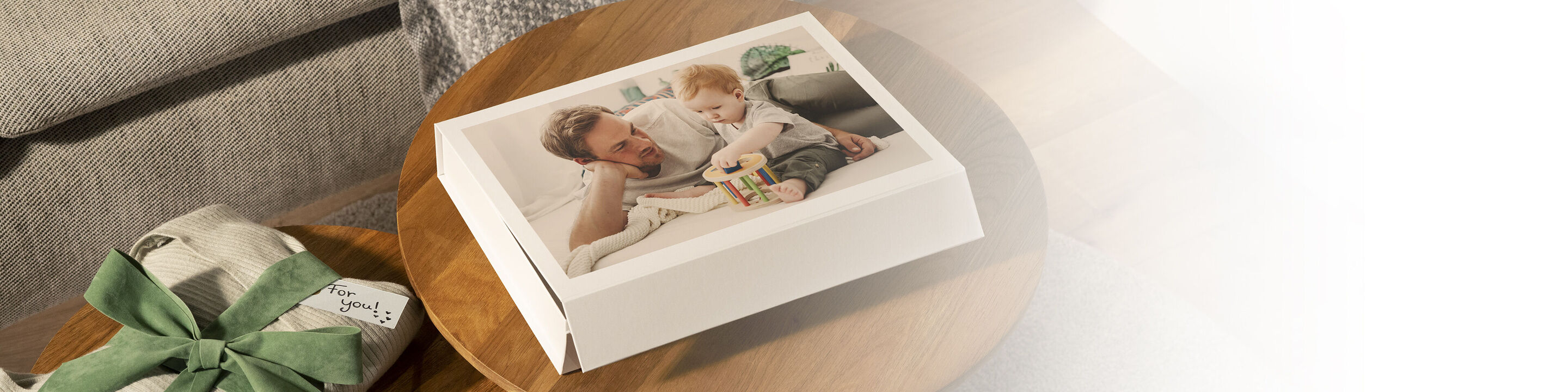 Un père joue avec son enfant sur une table, entouré de cadeaux.