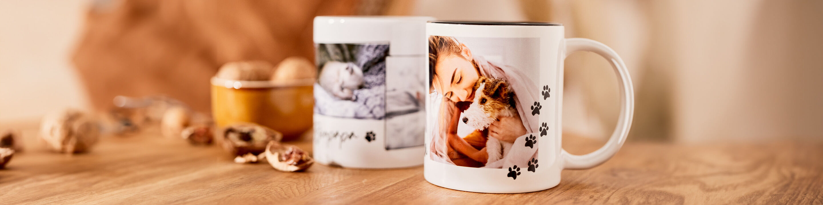 Twee gepersonaliseerde mokken op een tafel, een met een foto van een kat en een ander met een foto van een kind.